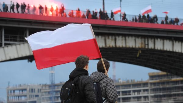 Молодые люди наблюдают за шествием националистов во время Национального праздника независимости Польши в Варшаве, 2015 год - اسپوتنیک ایران  