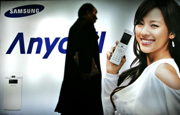 عابری که از کنار تبلیغ تلفن همراه سامسونگ می گذرد، کره جنوبی ، سال ۲۰۰۷ - اسپوتنیک ایران  