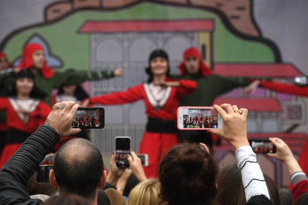 بازدیدکنندگان با تلفن همراه خود از نمایش رقص در فستیوال فرهنگ گرجستان فیلم می گیرند - اسپوتنیک ایران  