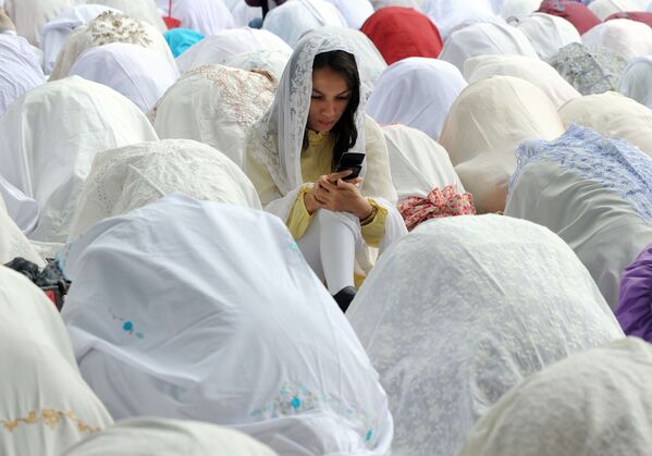دختر مسلمان با تلفن همراه خود در مراسم عید قربان در جاکارتا - اسپوتنیک ایران  