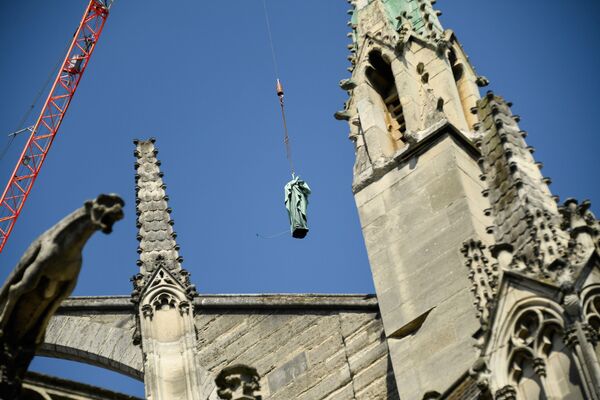 جرثقیل در حال بالابردان مجسمه مسی در کلیسای نوتردام پاریس - اسپوتنیک ایران  