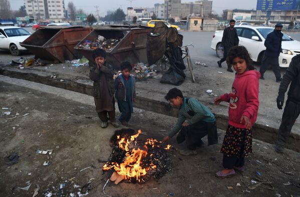 کودکان افغانی برای گرم شدن اشیای پلاستیکی را در کنار خیابانی در کابل آتش می زنند - اسپوتنیک ایران  