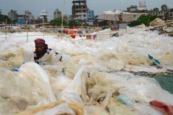 مردی در شهر داکا، پایتخت بنگلادش در بین اشیای پلاستیکی - اسپوتنیک ایران  