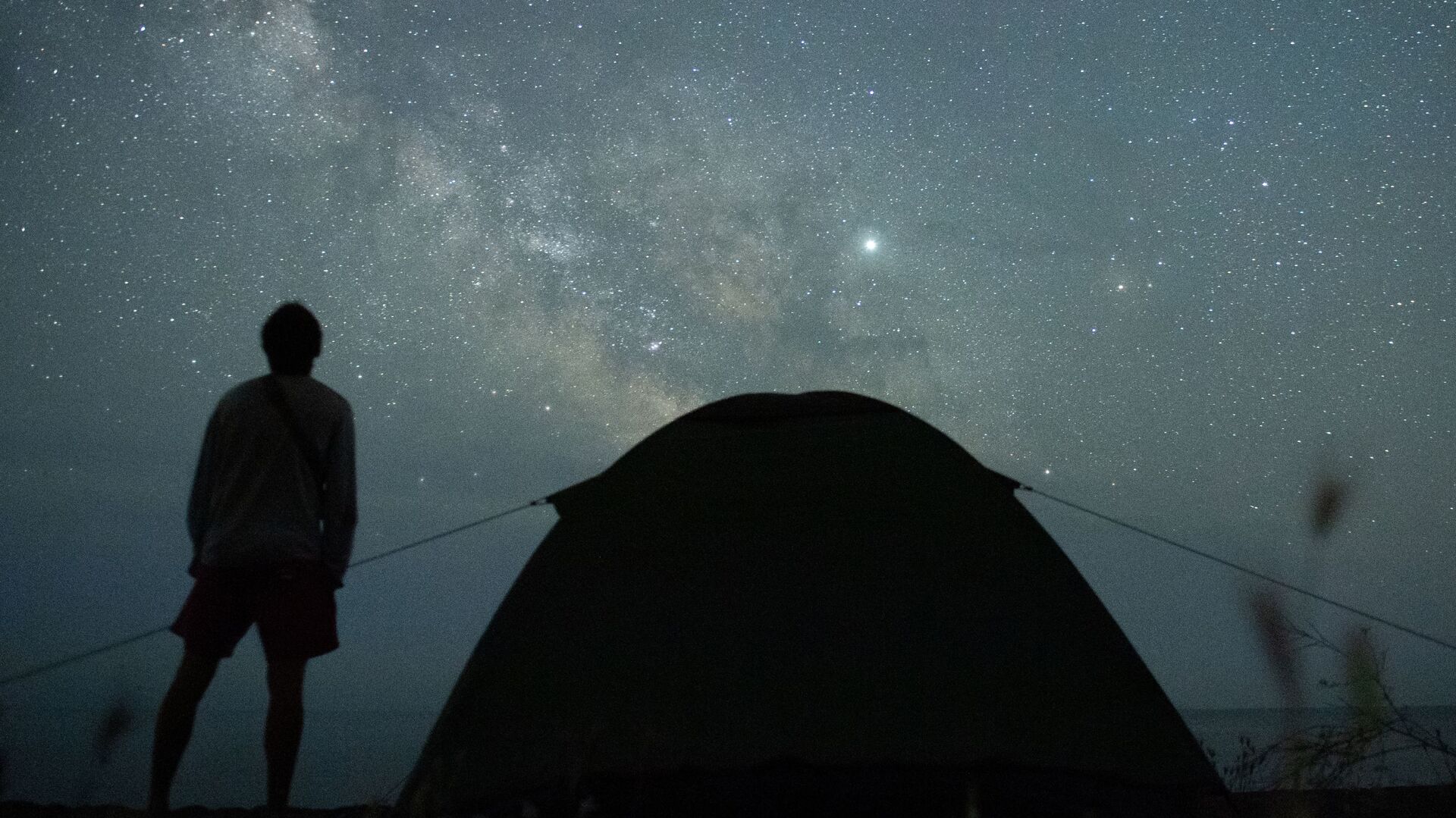 Мужчина наблюдает за звездным небом на берегу Черного моря возле поселка Морское в Крыму - اسپوتنیک ایران  , 1920, 24.03.2022