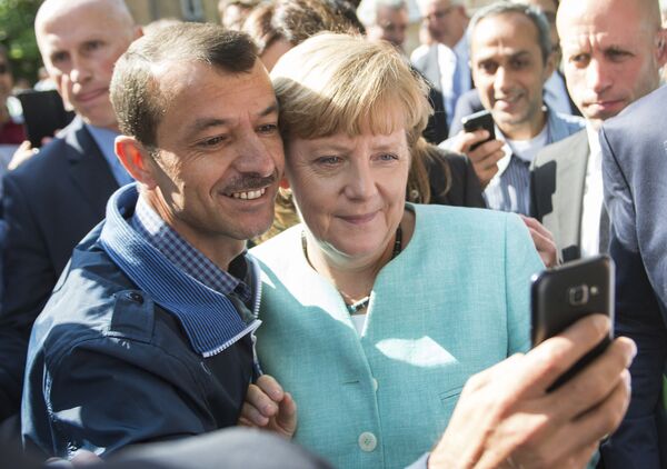 مهاجرین در حال گرفتن سلفی با صدر اعظم آلمان هنگام بازدید وی از مرکز پناهندگان در برلین - اسپوتنیک ایران  
