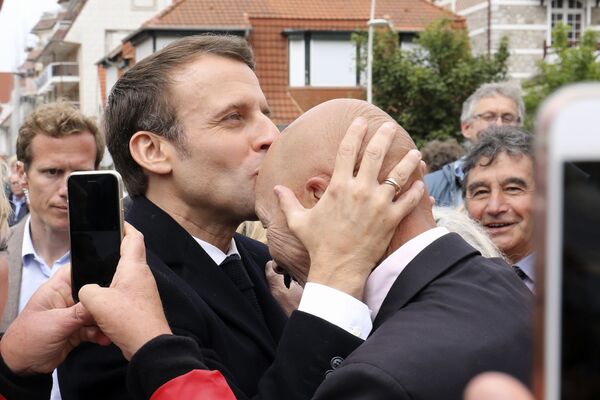 رئیس جمهور فرانسه امانوئل مکرون در حال بوسیدن طرفدار خود پس از رای گیری - اسپوتنیک ایران  