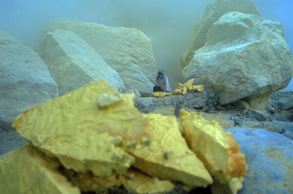 معدنچی در حال حمل سنگ گوگرد از کوه آتشفشانی کاوا ایجن در اندونزی - اسپوتنیک ایران  
