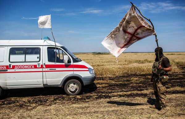 نظامی اوکراینی با پرچم سفید در زمان انتقال کشته شدگان در منطقه بی طرف  - اسپوتنیک ایران  
