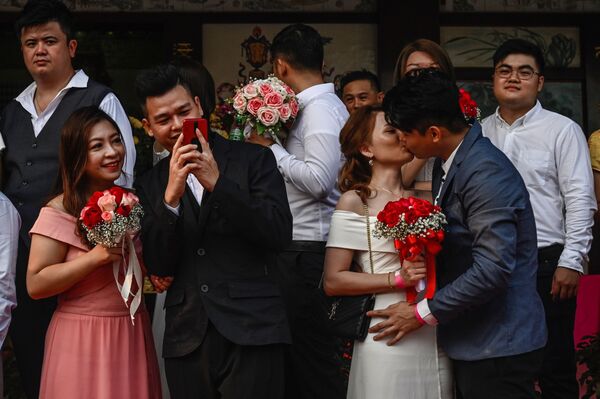 شرکت‌کنندگان مراسم گروهی ازدواج 99 زوج در تاریخ فرخنده9/9 در مالزی - اسپوتنیک ایران  