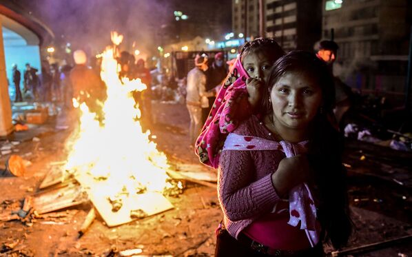 یک زن و دخترش در جریان اعتراضات در نزدیکی Casa de la Culture در کیتو، اکوادور - اسپوتنیک ایران  