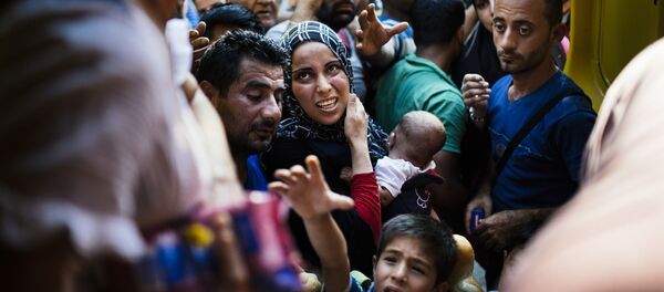 Мигранты в ожидании раздачи еды от македонских волонтеров на железнодорожной станции Гевгелия на македонско-греческой границе Мигранты в ожидании раздачи еды от македонских волонтеров на железнодорожной станции Гевгелия на македонско-греческой границе - اسپوتنیک ایران