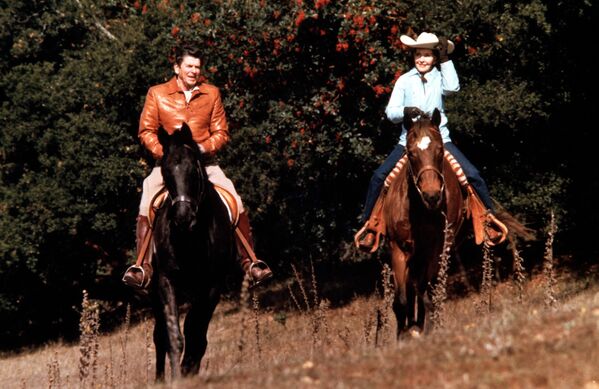 دونالد ریگان رئیس جمهور آمریکا همراه با همسرش ننسی سوار بر اسب در سال ۱۹۸۲ - اسپوتنیک ایران  