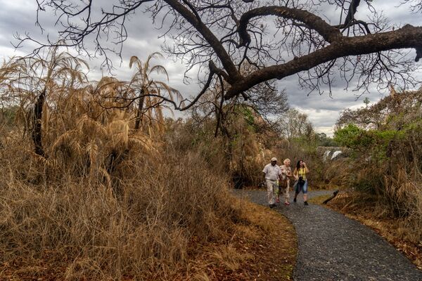 توریست ها همراه با راهنما کنار آبشار ویکتوریا، زیمباوه - اسپوتنیک ایران  