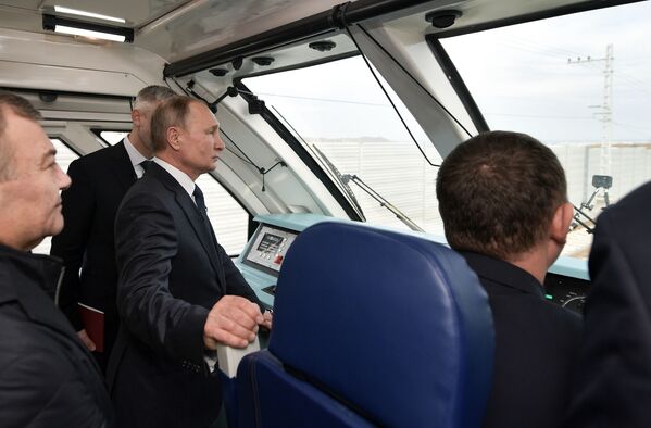 ولادیمیر پوتین رئیس جمهور روسیه در اتاقک هدایت اتوبوس ریلی که برای اولین بار از روی ریل در پل کریمه عبور می کند - اسپوتنیک ایران  