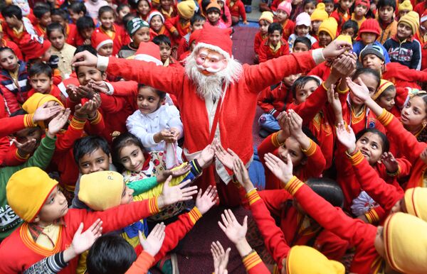 دختری در لباس بابا نوئل در حال پخش کردن هدایا در هند - اسپوتنیک ایران  