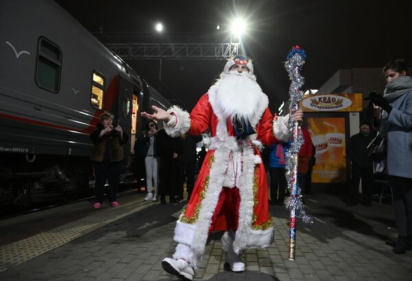 مردی در لباس بابانوئل کنار اولین قطار مسافربری سنت پترزبورگ-کریمه - اسپوتنیک ایران  