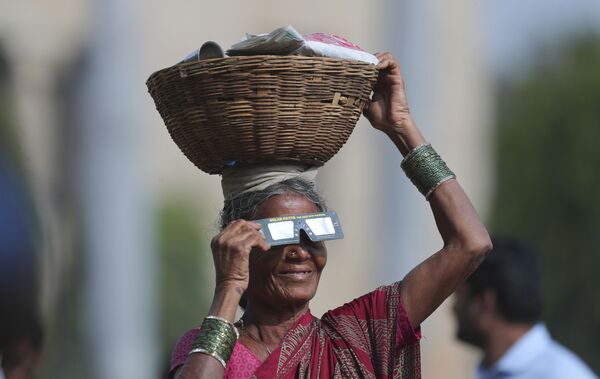 زنی در هند در حال مشاهده خورشید گرفتگی با عینک مخصوص - اسپوتنیک ایران  