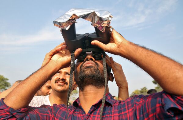 مردی در حال مشاهده خورشید گرفتگی در هند - اسپوتنیک ایران  