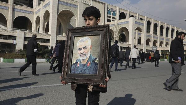 A boy carries a portrait of Iranian Revolutionary Guard Gen. Qassem Soleimani - اسپوتنیک ایران  