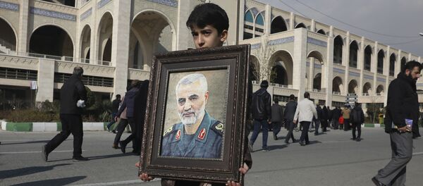 A boy carries a portrait of Iranian Revolutionary Guard Gen. Qassem Soleimani - اسپوتنیک ایران  