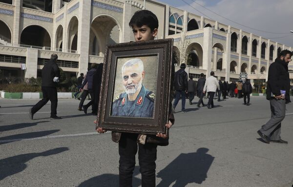 کودکی عکس سردار سلیمانی را در دستانش گرفته است - اسپوتنیک ایران  
