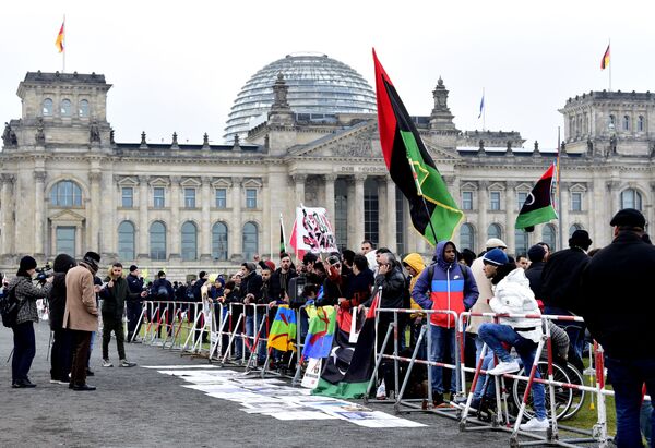 تظاهرکنندگان با پرچم لیبی در زمان برگزاری کنفرانس بین المللی لیبی در برلین - اسپوتنیک ایران  