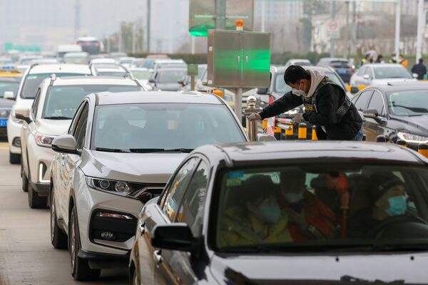 اندازه گیری دمای بدن مسافران خودروها  در شهر ووهان چین  - اسپوتنیک ایران  