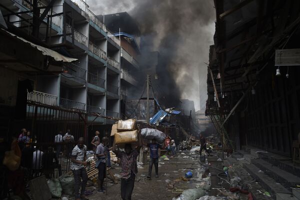 مردم کالاهایی نجات یافته از آتش سوزی را در منطقه بازار بالوگون در لائوس حمل می کنند - اسپوتنیک ایران  