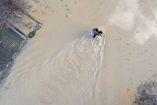 مردی در خیابان آب گرفته در شهر گاریاچی کلیوچ منطقه کراسنودار - اسپوتنیک ایران  