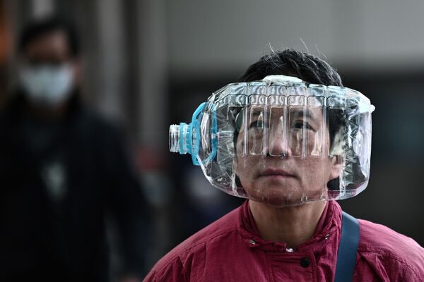یکی از ساکنین هنگ کنگ با بطری پلاستیکی به شکل ماسک برای دفاع در مقابل ویروس کرونا - اسپوتنیک ایران  