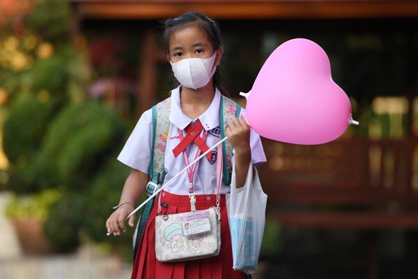 دانش آموزی با ماسک در روز جشن ولنتاین در تایلند - اسپوتنیک ایران  