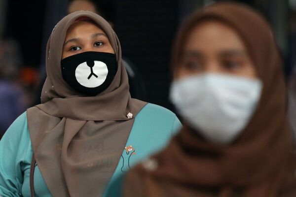 مسافری با ماسک در قطار مالزی - اسپوتنیک ایران  