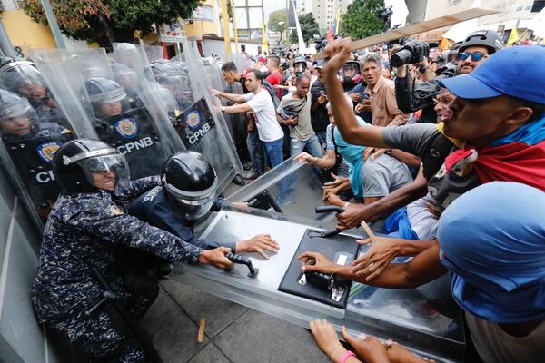 برخورد تظاهرکنندگان با پلیس در کاراکاس ونزوئلا - اسپوتنیک ایران  
