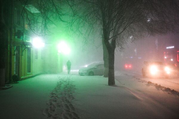 مردی در حال قدم زدن در زیر بارش  برف در پادولسک - اسپوتنیک ایران  
