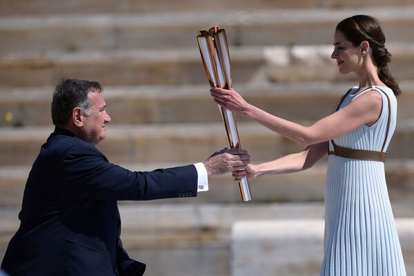 مراسم انتقال مشعل المپیک به ژاپن
هنرپیشه یونانی مشعل را به دست وزیر ورزش یونان می دهد - اسپوتنیک ایران  