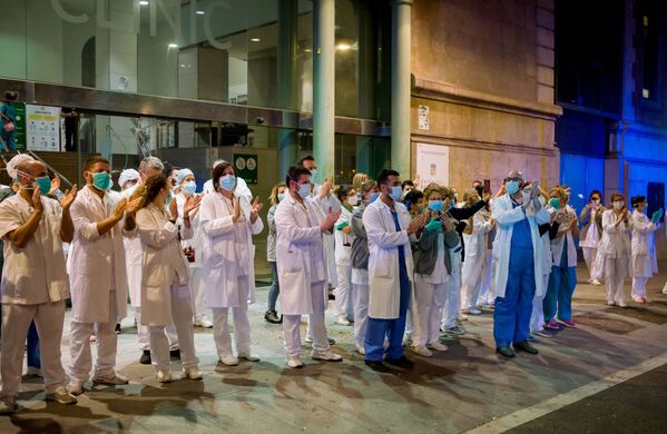 کادر پزشکی در کنار ساختمان بیمارستان بارسلون برای مردمی که آنها را از بالکون های خانه هایشان حمایت کردند، دست می زنند - اسپوتنیک ایران  