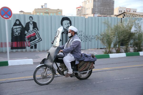 موتورسوار ماسک زده به صورت در خیابان های قم، ایران - اسپوتنیک ایران  