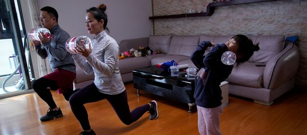 خانواده ای مشغول تمرین ورزشی آنلاین در خانه شان در شانگهای چین  - اسپوتنیک ایران  