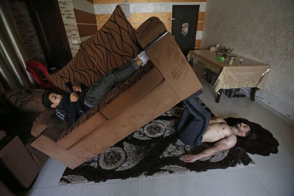 مربی فلسطینی احمد ساوی در حال تمرین در خانه اش در غزه - اسپوتنیک ایران  