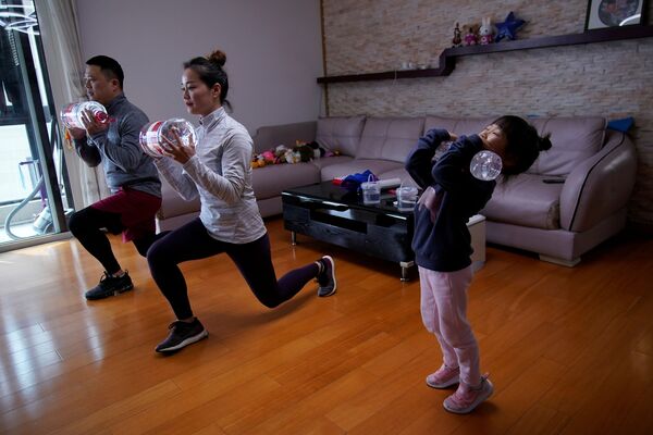 خانواده ای مشغول تمرین ورزشی آنلاین در خانه شان در شانگهای چین  - اسپوتنیک ایران  
