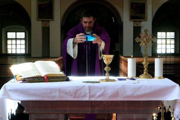 کشیش در حال برگزاری مراسم کلیسا به صورت آنلاین در اسلوونی - اسپوتنیک ایران  