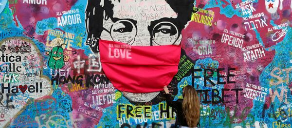 زنی با ماسک در کنار دیوار معروف جان لنون در پراگ زنی با ماسک در کنار دیوار معروف جان لنون در پراگ - اسپوتنیک ایران