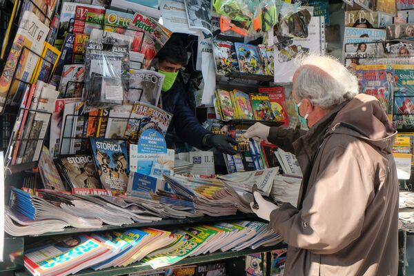 مردی با ماسک در حال خرید روزنامه در ونیز - اسپوتنیک ایران  