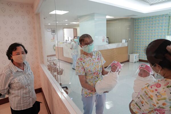 پرستاران با ماسک کودک تازه متولد شده را جابه جا می کنند ، بانکوک تایلند - اسپوتنیک ایران  