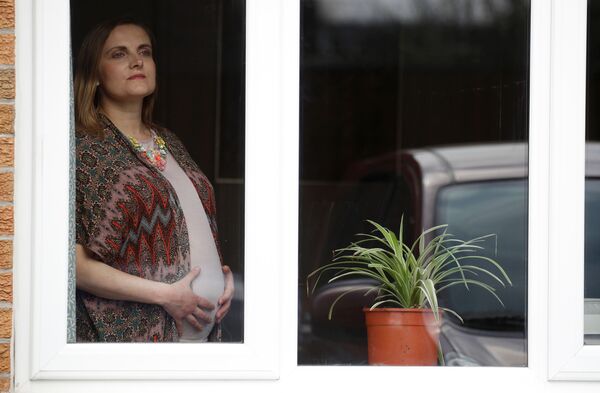 زن باردار کنار پنجره در خانه اش در منچستر بریتانیا - اسپوتنیک ایران  
