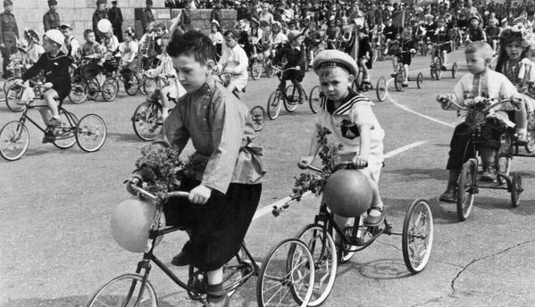بچه ها مشغول دوچرخه سواری در راهپیمایی اول ماه می در استالینگراد، سال ۱۹۴۶ - اسپوتنیک ایران  