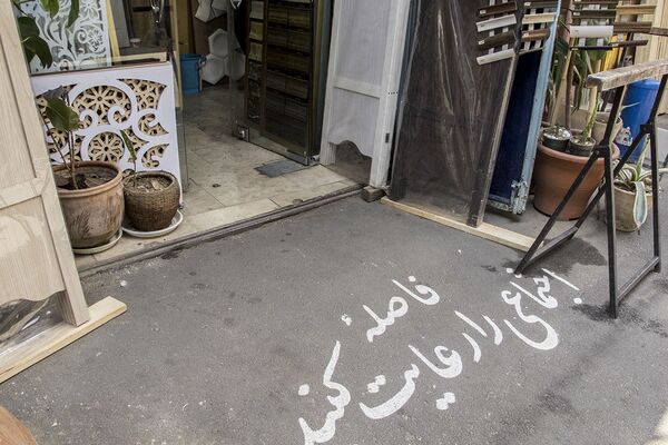 روی کف ورودی مغازه ای در تهران: فاصله اجتماعی را رعایت کنید! - اسپوتنیک ایران  