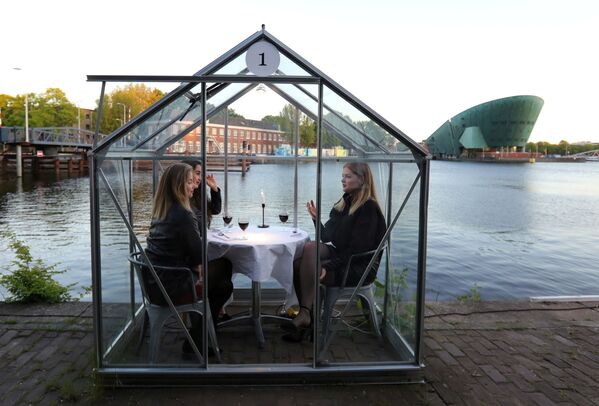 مدل ها در حال آزمایش رستوران به شکل «اتاقک قرنطینه» در آمستردام - اسپوتنیک ایران  