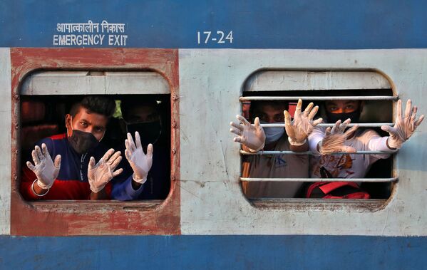 مسافران از پنجره قطاری در هند دست تکان می دهد
 - اسپوتنیک ایران  