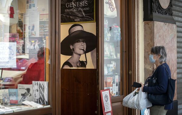زنی با ماسک پزشکی در یک کتاب فروشی در تورین، ایتالیا
 - اسپوتنیک ایران  